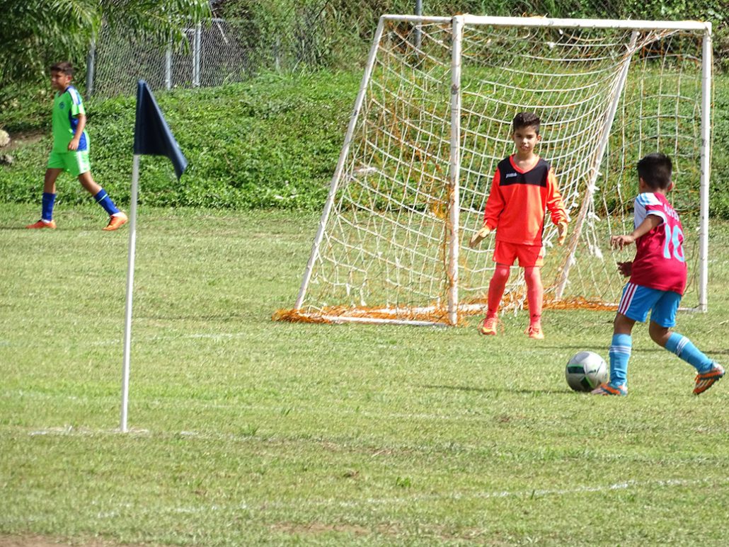 Jugada de fútbol juvenil de Manatí FC cerca de la portería
